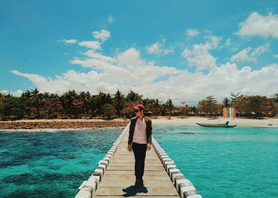 Man standing by swimming pool against sky