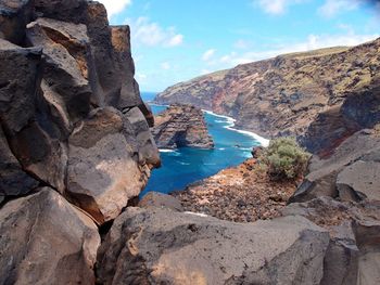 Rock formations by sea against sky