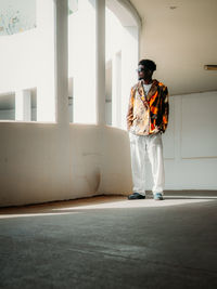 Portrait of young man standing against wall