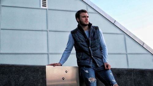 Young man standing against wall