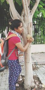 Full length of woman standing on tree trunk