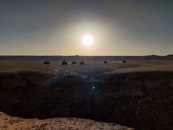 People on land against sky during sunset
