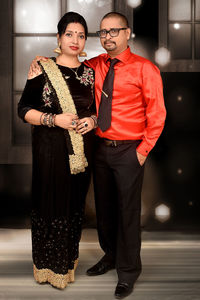 Young couple standing against wall