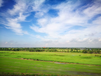 Scenic view of green landscape against blue sky