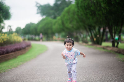 Cute girl standing against trees