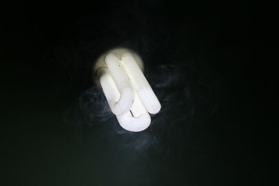 Close-up of light bulb over black background
