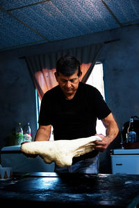 Portrait of man preparing dough for bread