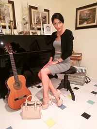 Full length portrait of woman sitting on chair