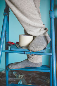 Low section of man standing on ladder