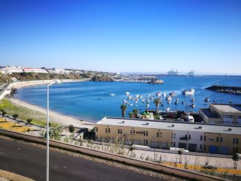 High angle view of harbor by sea against clear blue sky