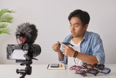 Man looking at camera while sitting on table