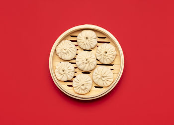 Directly above shot of cupcakes against red background