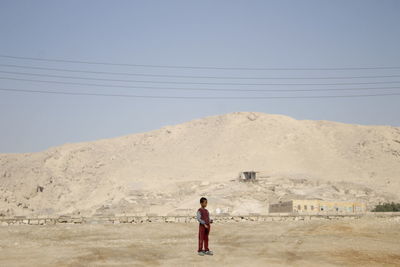 Rear view of man standing on desert