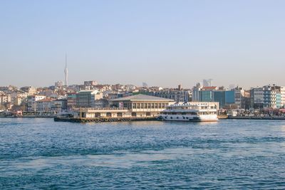 Buildings by sea against clear sky. 