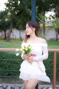 Portrait of young woman holding flower bouquet