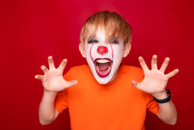 Portrait of baby boy against red background