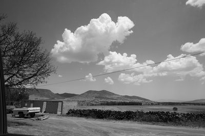 Scenic view of road by mountains against sky