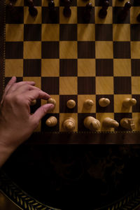 Cropped hand of woman holding chess piece