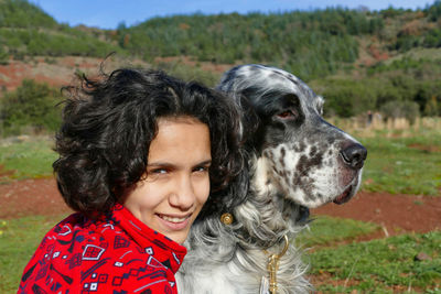 Portrait of a young woman in warm clothing and her english setter dog in european landscape