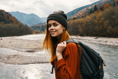 Portrait of smiling young woman standing in snow