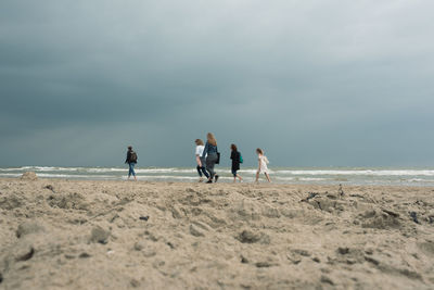 People on beach against sky