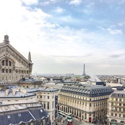 Buildings in city against cloudy sky