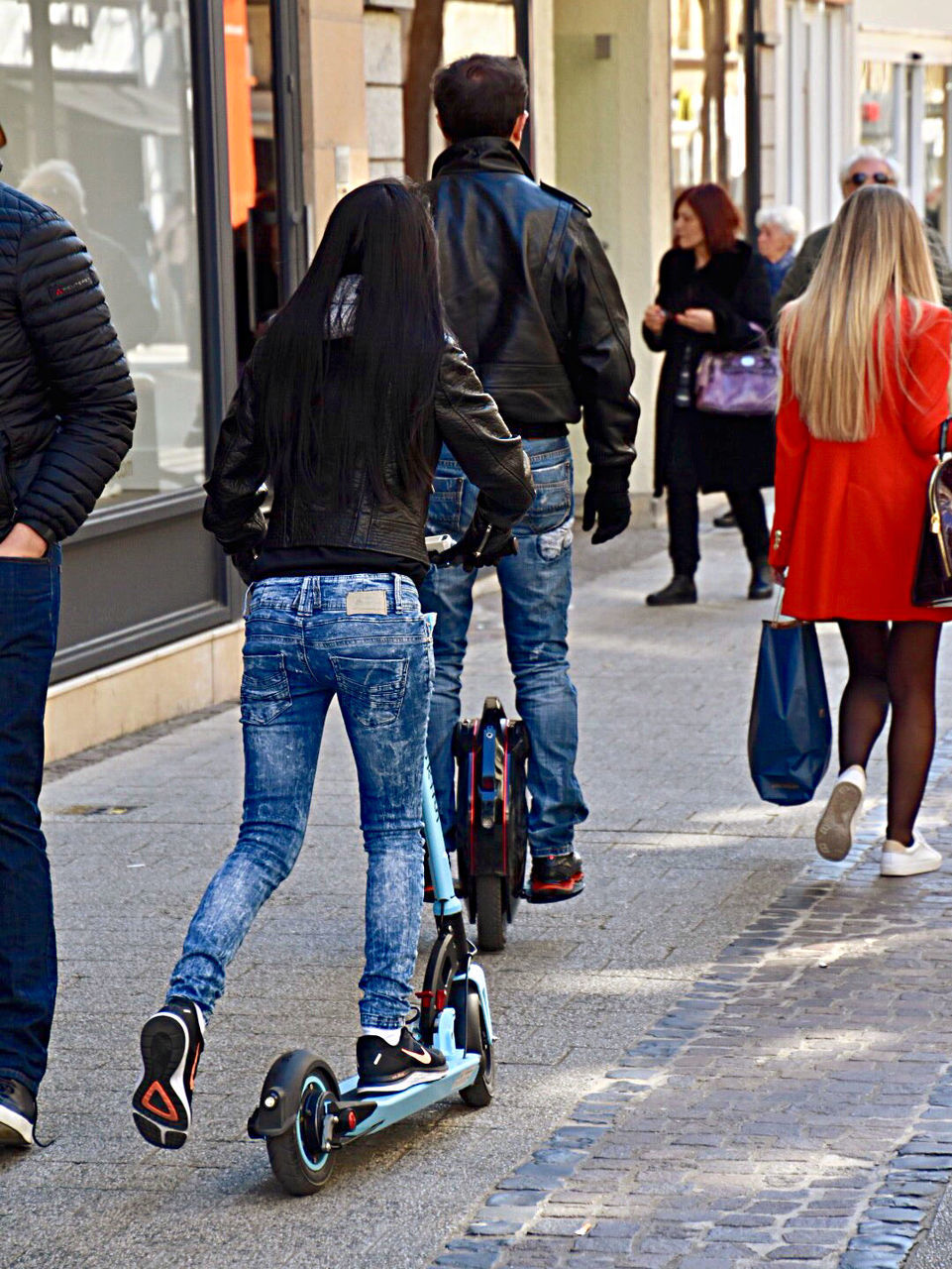 REAR VIEW OF PEOPLE RIDING BICYCLES ON STREET