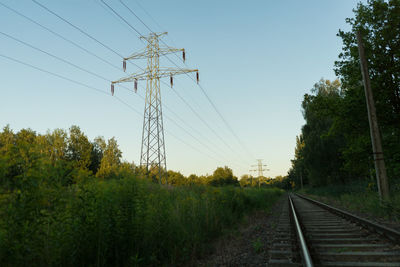Railroad track amidst trees against clear sky