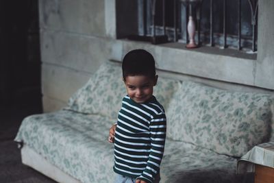 Smiling boy looking away while standing at home