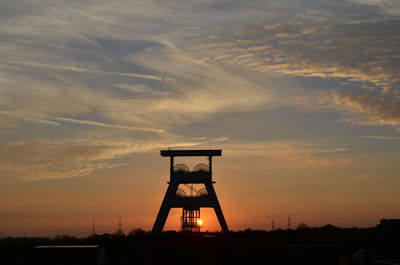 Silhouette tower against sky during sunset