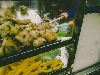 Close-up of man working on barbecue grill