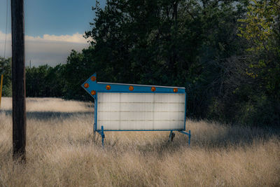 Empty signboard in field of dry grass