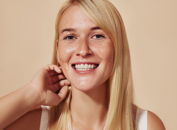 Portrait of young woman against wall