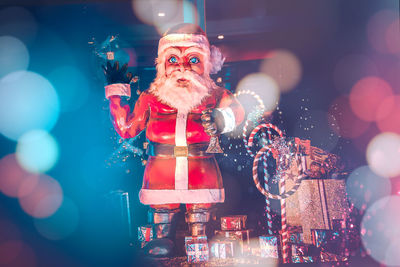 Close-up of santa clause with gifts against black background
