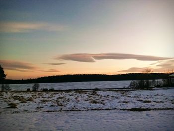 Scenic view of frozen lake against sky during sunset