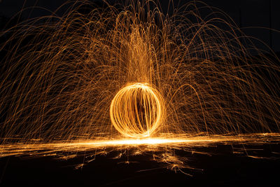 Illuminated wire wool spinning at night