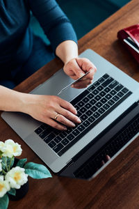Woman doing online shopping using debit card and laptop. female hands holding credit card