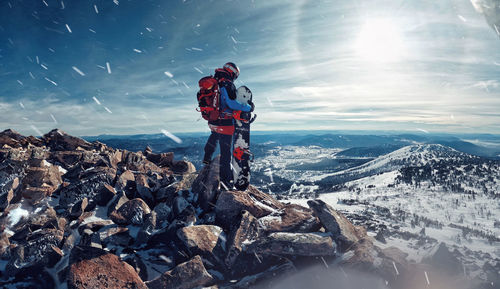 People on rocks against mountains