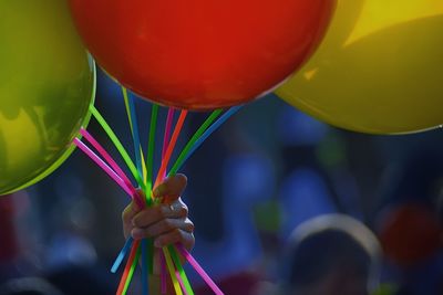 High angle view of hand holding colorful balloons
