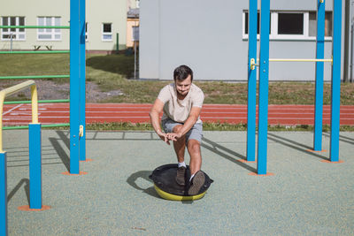 Professional athlete perform squat with his own weight on balance apparatus for more intense workout