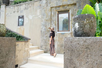 Full length of woman standing against building