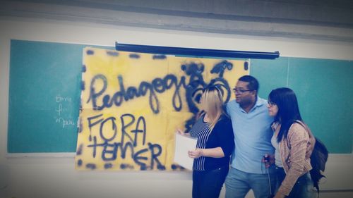 Woman standing against yellow wall