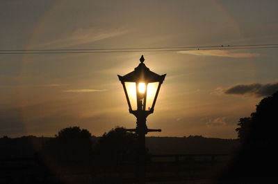 Illuminated lamp against sky