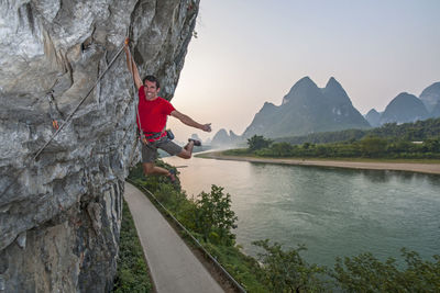 Man climbing river side in yangshuo, a climbing mekka in china