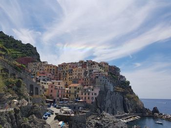 Panoramic view of town by sea against sky