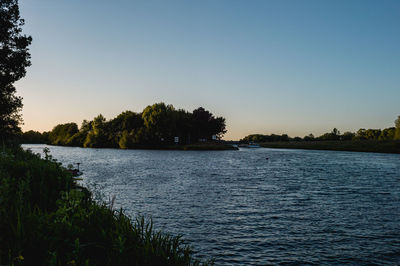 Scenic view of lake against clear blue sky