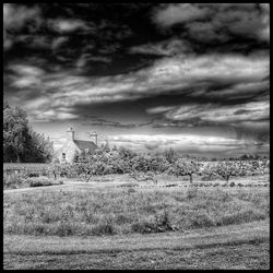 Scenic view of field against cloudy sky