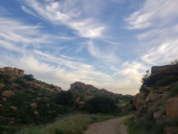 Road amidst rocks against sky