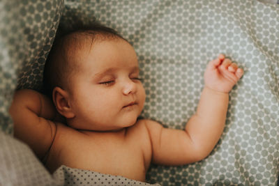 Cute baby girl sleeping on bed