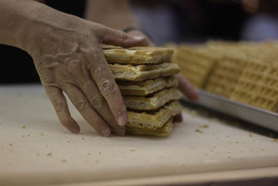 Persons hand holding stack of waffles